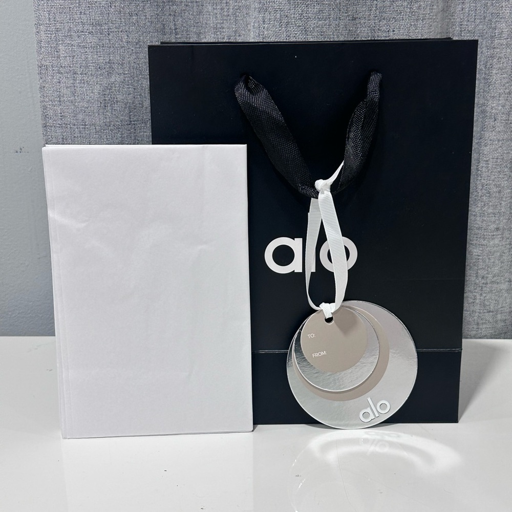 ALO black and white, empty paper bag with tissue paper and holiday gift charm. - Picture 2 of 5